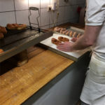 Tie-shaped doughnut being covered in sugar at Bakery Roth in Erfurt
