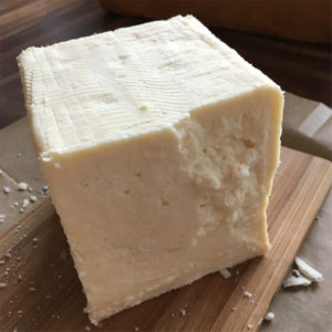 Unwrapped Caerphilly cheese wedge