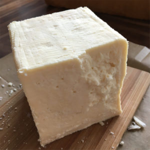 Unwrapped Caerphilly cheese wedge