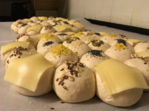 A mix of bread rolls with various toppings