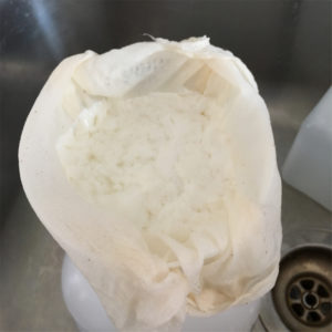 Kefir draining in cheesecloth in sink